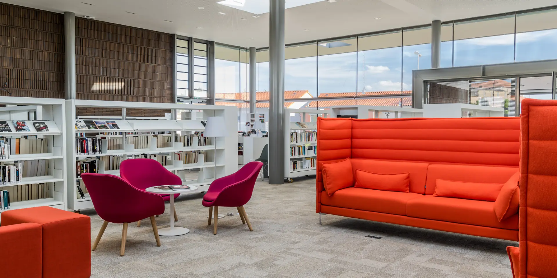 Espace intérieur de la médiathèque de Lezoux, médiathèque et culture, avec sièges de lecture et rayonnages de ressources
