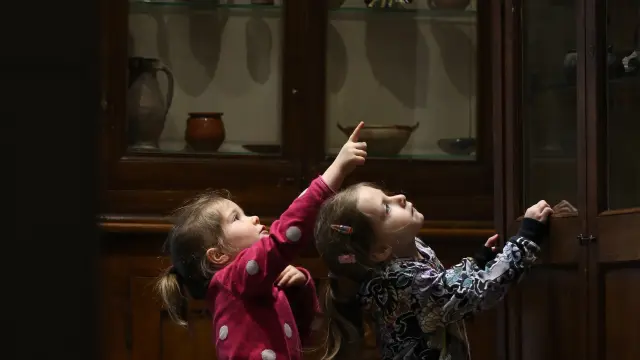 Deux enfants observent des céramiques anciennes en vitrine au Musée de la Céramique à Lezoux