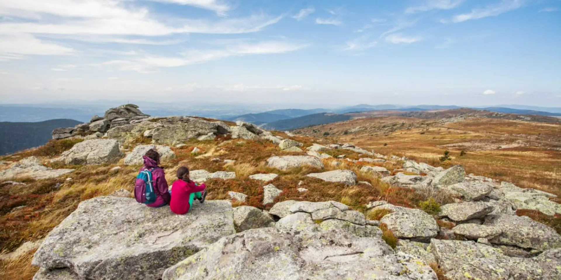 Une famille profite d’une vue panoramique sur les monts du Forez depuis le col du Béal en automne.