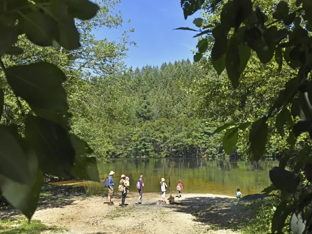 Une famille observe la retenue d’eau du barrage de la Muratte depuis une plage naturelle à Palladuc.