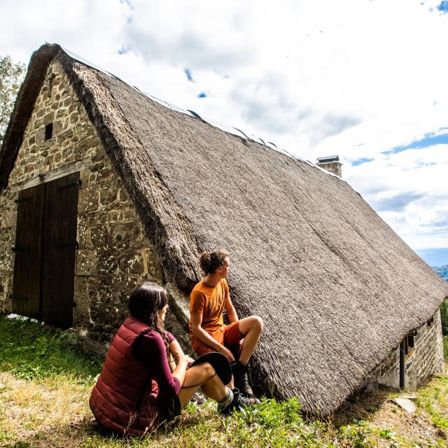 Couple devant une jasserie, admirant le paysage environnant.