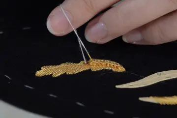 Broderie au fil d'or en cours de réalisation à la Maison des Grenadières, Cervières