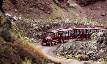 Petit train rouge (autocar) transportant des vacanciers pour la visite du volcan de Lemptégy, chaîne des Puys
