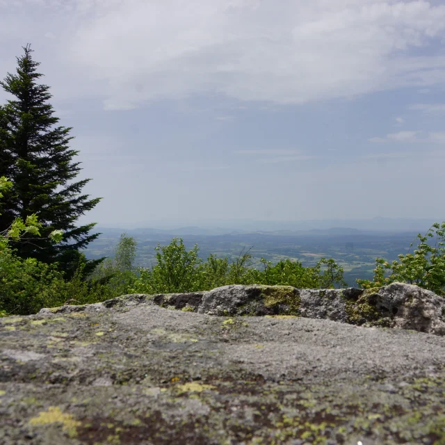 Paysage du Grün de Chignore, avec rocher et vue panoramique sur les montagnes.