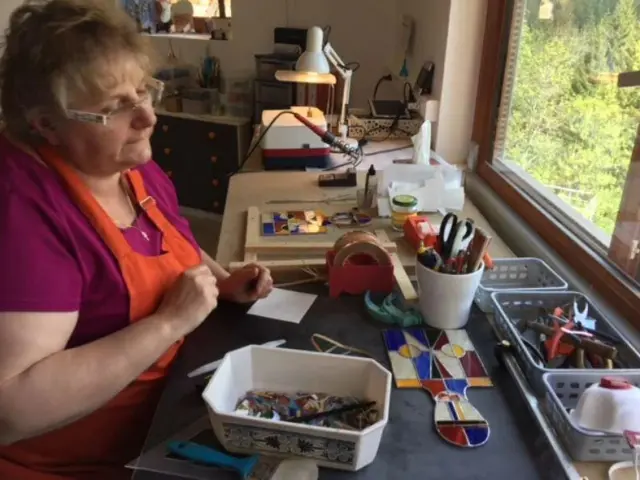 La vitrailliste Marie-Paul Dauphin travaille à la confection de vitraux sur son bureau à Auzelles