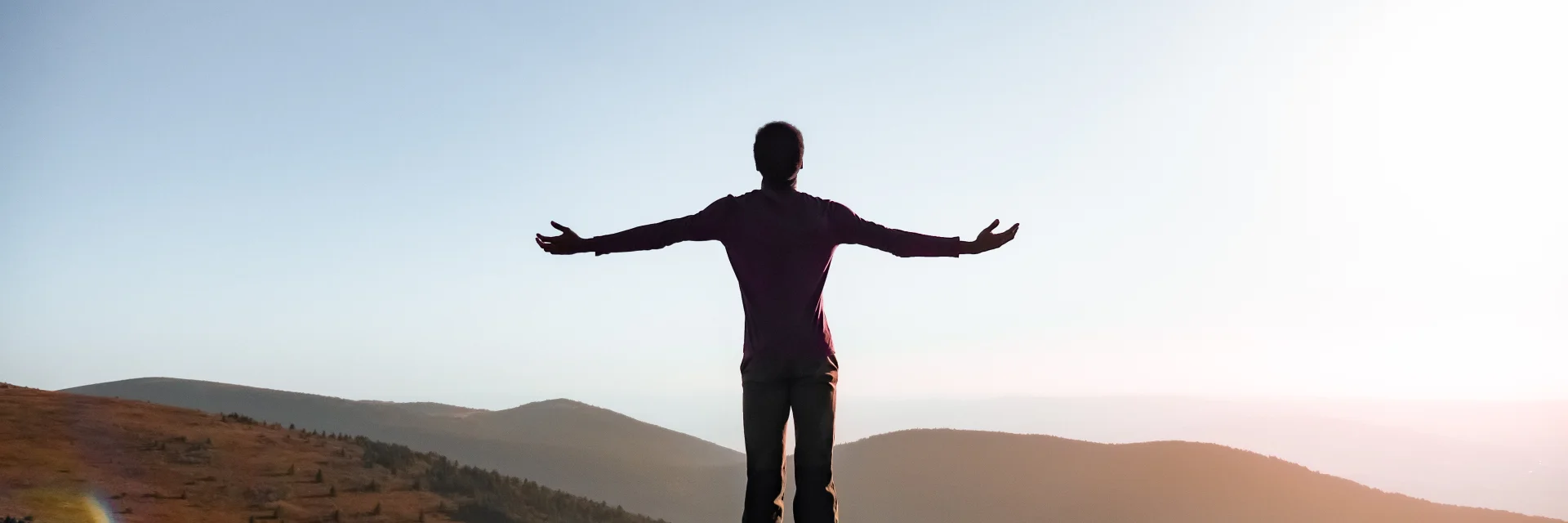 Un randonneur, à Peyre Mayou, face à l’horizon, bras ouverts, contemple les vastes paysages du Livradois-Forez au lever du soleil. Capturée en Auvergne, cette image évoque la liberté, l’évasion et le ressourcement au cœur de la nature. Parfaite illustration d’un séjour bien-être, d’une escapade randonnée ou d’une expérience de déconnexion totale en montagne. Ciel dégagé, lumière dorée et panorama époustouflant : une invitation à explorer les grands espaces d’Auvergne.