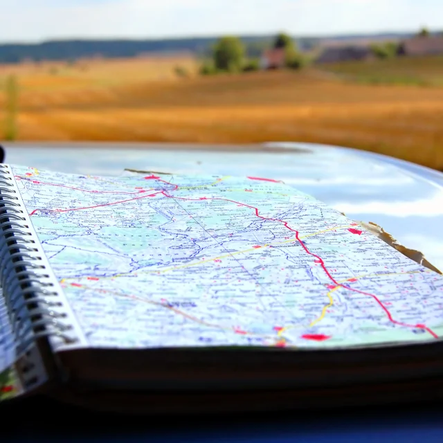 Map on car mask, on second plan summer holidays scenery
