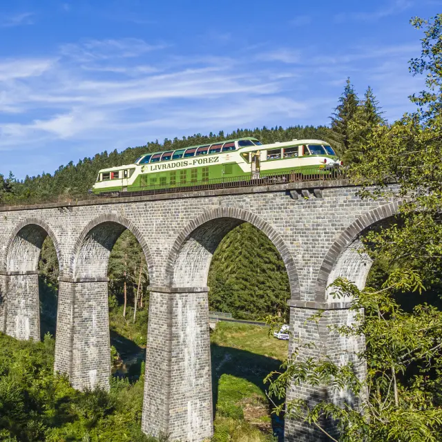 Le train touristique d’Agrivap traverse un pont en été dans les paysages du Livradois-Forez.