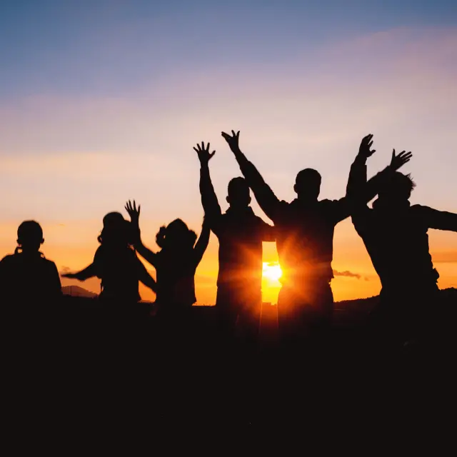 Groupe de personnes admirant un coucher de soleil au crépuscule dans le Livradois-Forez.